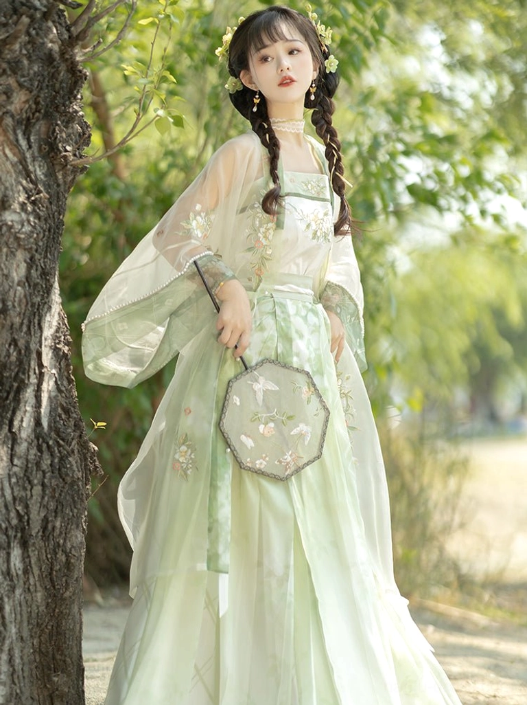 Front view of lightweight sheer green and white Song Dynasty Hanfu set with floral details and pleated skirt under woodland trees