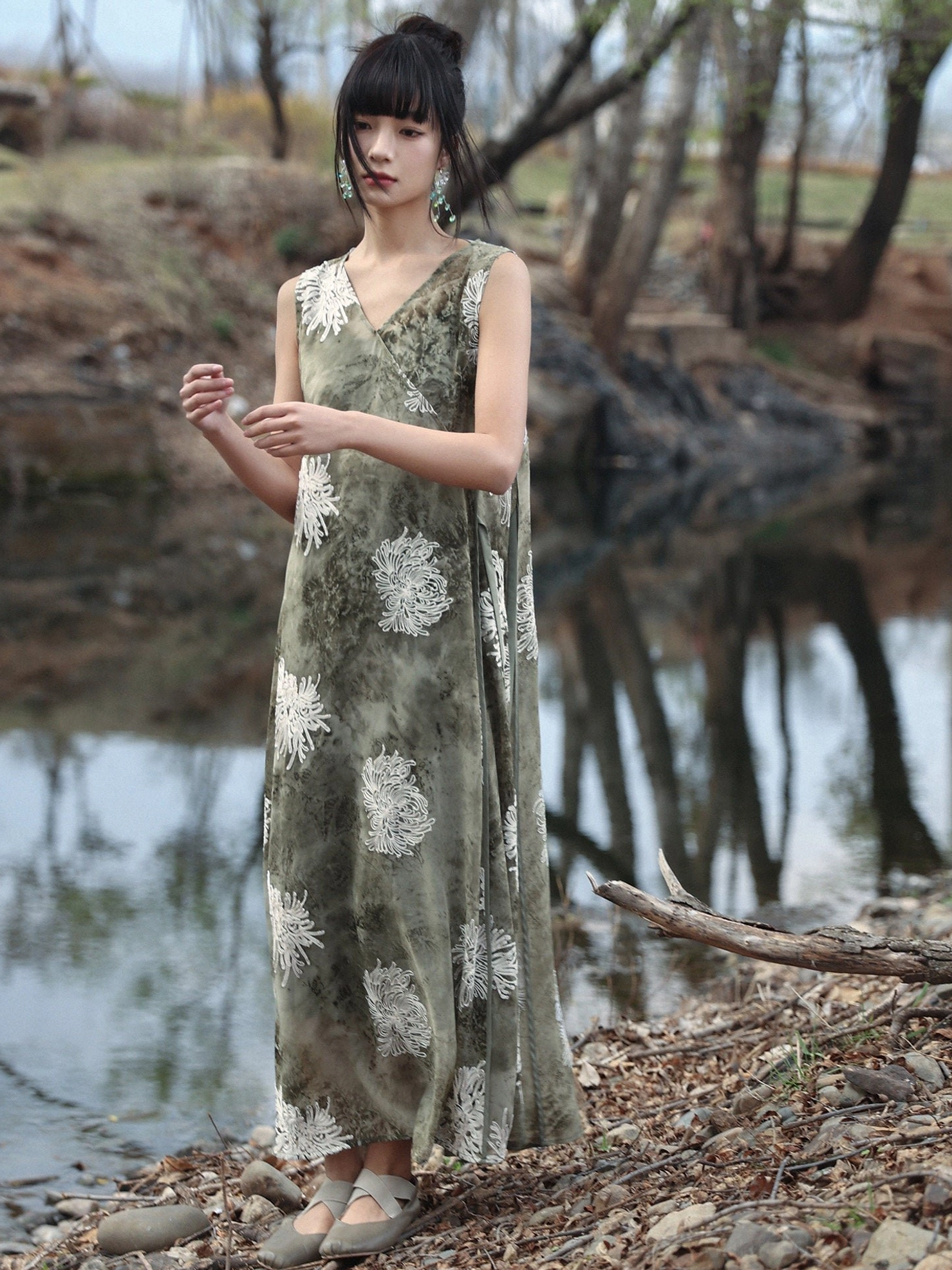 Front view of a lightweight sage green summer dress with natural tie-dye pattern, off-white chrysanthemum flowers, and flowing maxi length