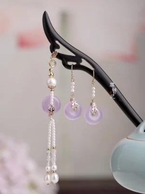 Lilac peace buckle Chinese hairpin and matching pearl tassel earrings set displayed on a carved black wooden hairpin stand