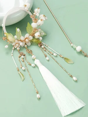 Lily of the valley Chinese hair accessory set displayed flat with circular hair frame matching hair stick green leaves white bell flowers gold chains and tassels