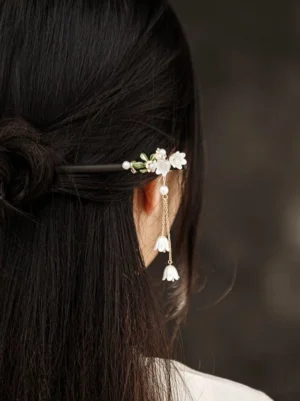 Back view of lily of the valley pearl tassel Chinese hair stick worn in a long black half-up hairstyle