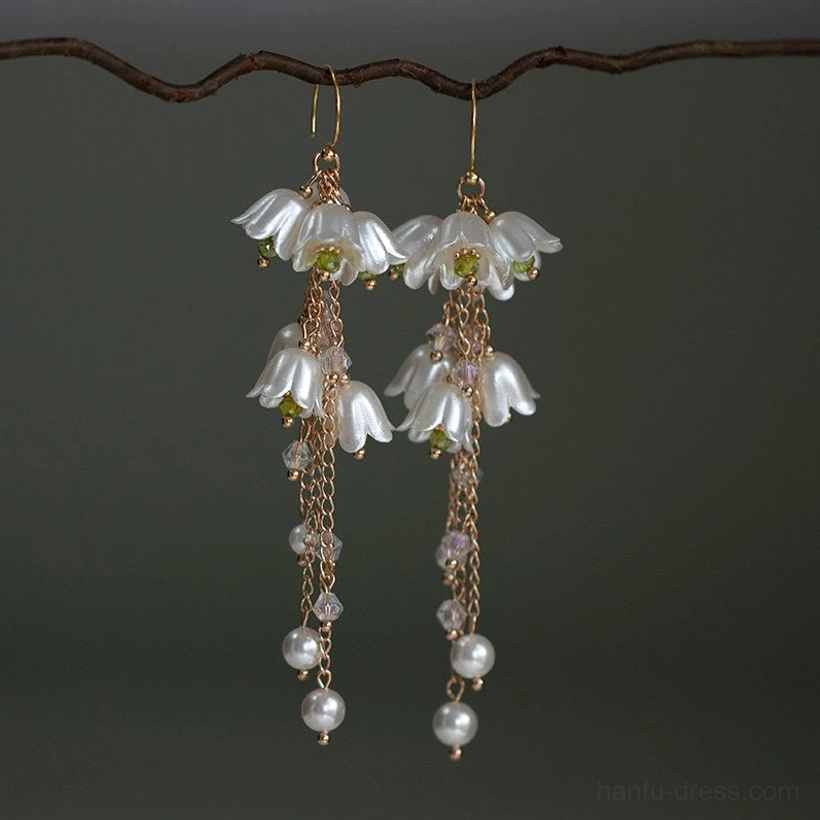 Pair of lily of the valley vintage drop earrings with gold hooks, milky white bell-shaped flowers, long chain tassels, beads, and imitation pearl pendants