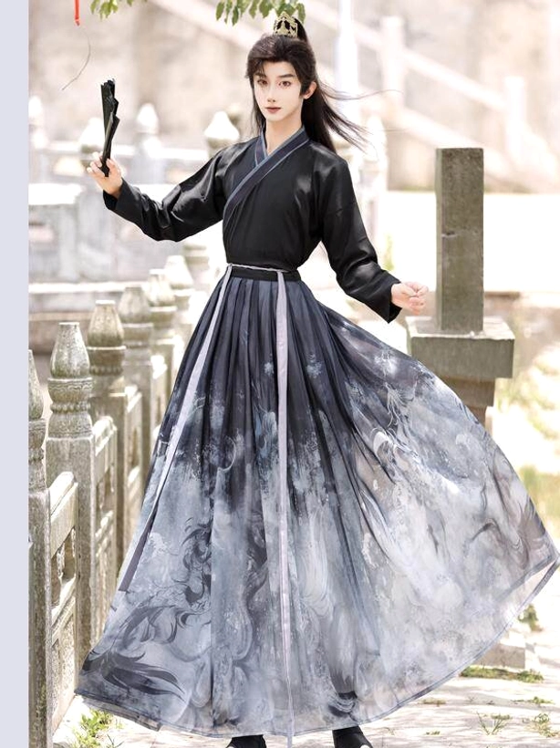 Male model wearing the inner vest and skirt layers of black ink-wash Xianxia hanfu set with purple waist sash and folding fan in traditional garden