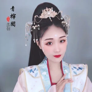 Model wearing blue and white embroidered Hanfu with Linyu floral Chinese hair crown and tassel hairpins in amethyst colorway