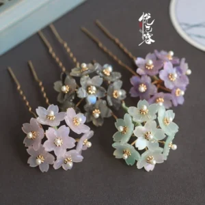 Three color options of Little Hydrangea Chinese Hanfu hair pins with translucent resin flower petals pearl accents and golden wavy hair sticks arranged on a dark background