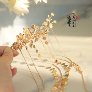 Close-up of a Liudai Chinese Hanfu hairpin with carved floral and leaf details, delicate chain tassels, and rhombus-shaped gold-tone pendants