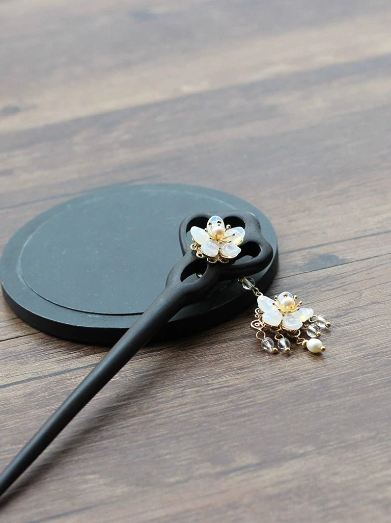 Side view of Liuying black carved wood Chinese hair stick with openwork flower handle and detached pearl tassel charm