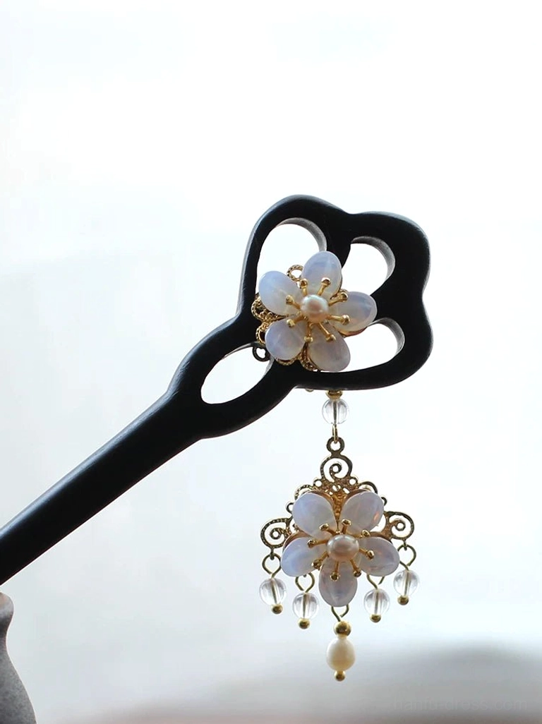 Liuying black wood Chinese hair stick held in hand with white floral ornament, gold filigree, crystal beads and pearl tassel