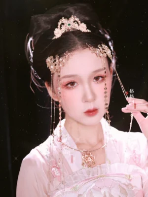 Close-up of Liuyun Hanfu forehead tassel crown with delicate gold floral engraving, jewel embellishment, and long hanging beaded tassels