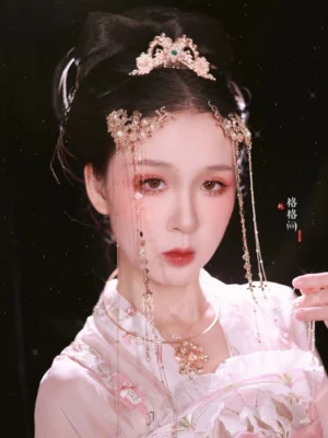 Liuyun traditional Chinese Hanfu hair accessory set with gold floral forehead tassel crown, green gemstone-style accent, long beaded chains, and pink embroidered Hanfu styling