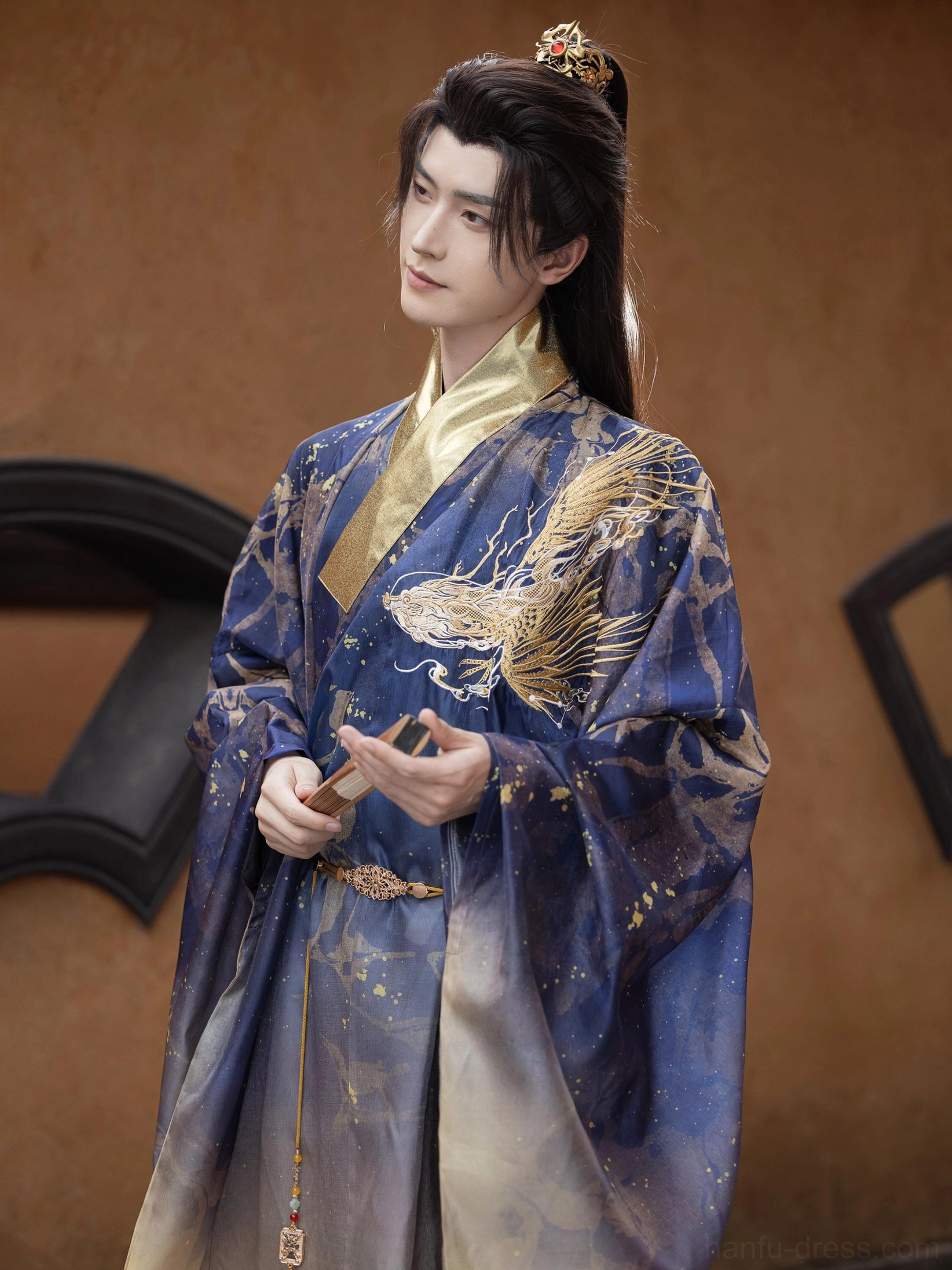 Close side view of Long Yin Chinese ancient style male Hanfu with gold dragon embroidery, navy fabric, gold splatter pattern and gradient golden hem