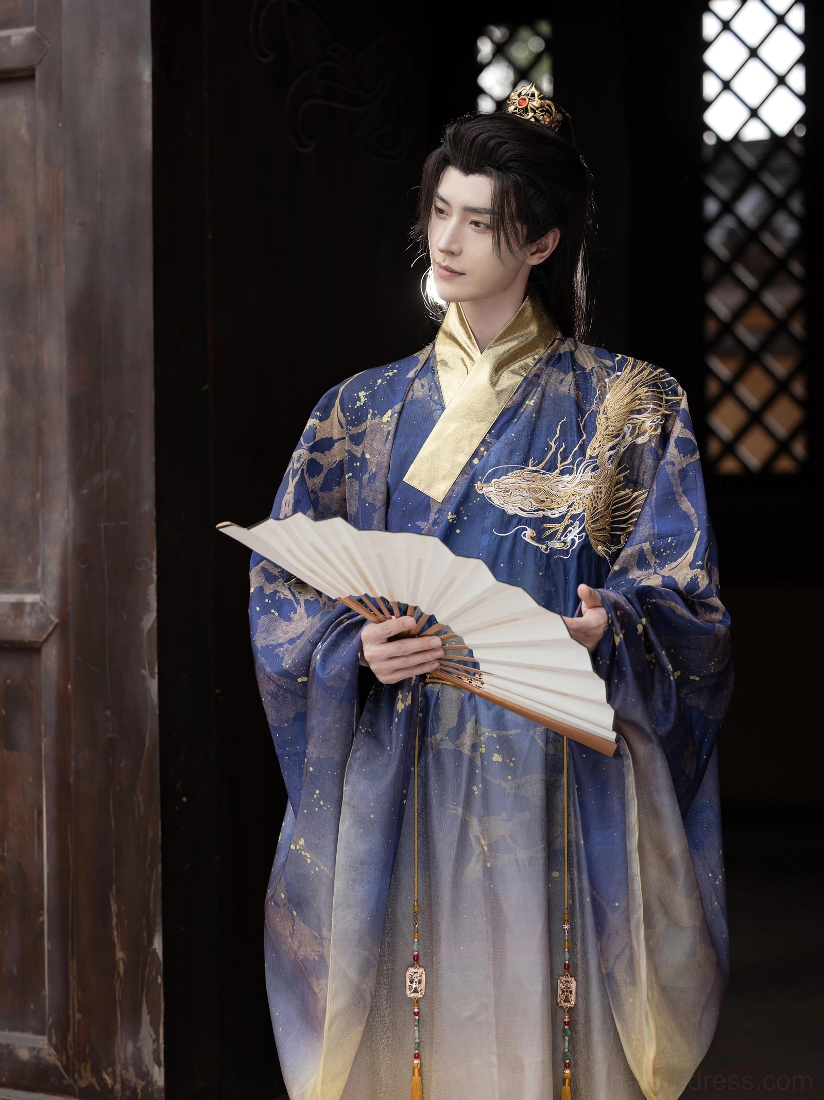 Men's Long Yin dragon embroidered Hanfu robe inspired by Ming Dynasty daopao, front three quarter view showing blue gold gradient and waist tassels