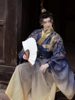 Long Yin Ming Dynasty inspired dragon Taoist robe for men in navy blue and gold gradient, low angle seated Hanfu styling with wide flowing sleeves