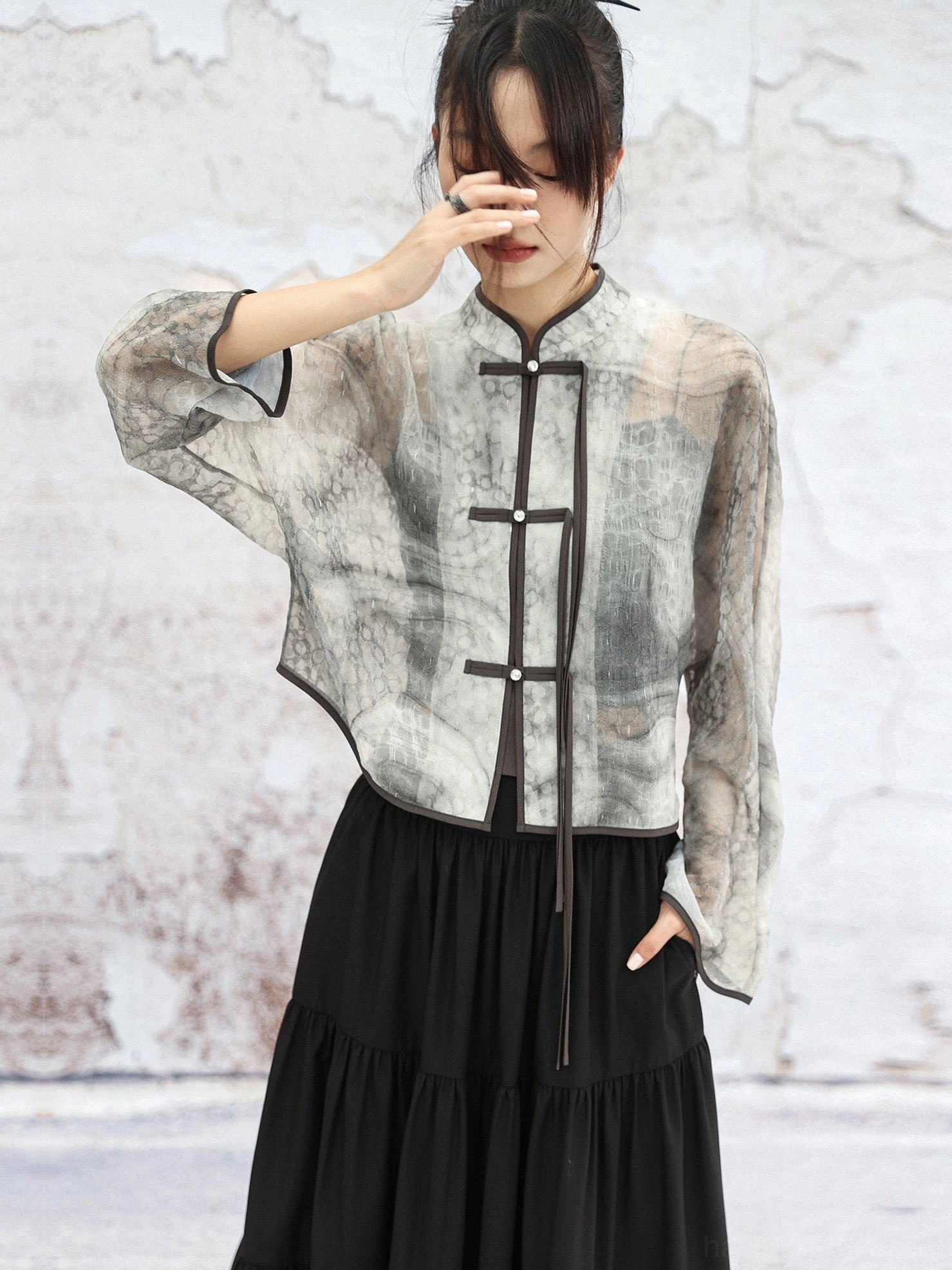Front view of loose cropped modern Hanfu jacket with Mandarin stand collar, decorative frog fasteners, and sheer watercolor ink print