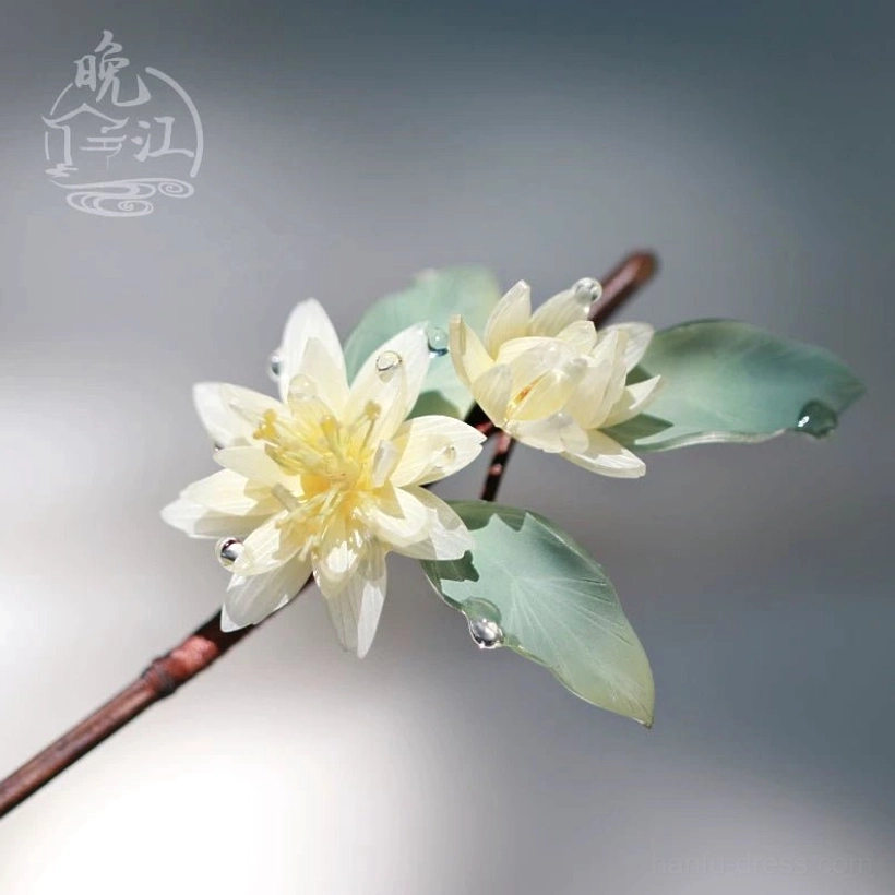 Close-up left view of lotus flower Chinese hair stick with cream layered blossoms green leaves clear dewdrop accents and reddish brown wooden stem