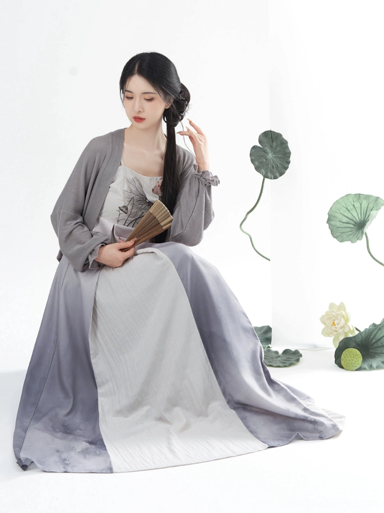 Seated view of lotus ink Tang style Hanfu slip dress and grey cropped cardigan with flowing skirt