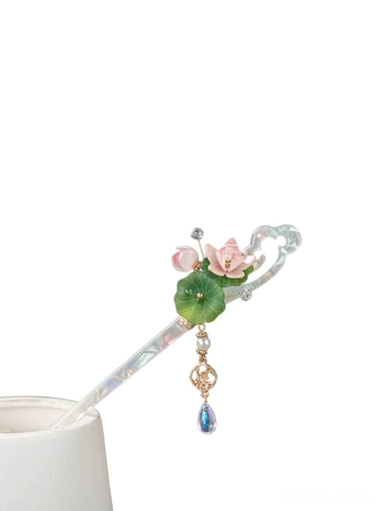 Lotus themed Chinese hair stick displayed on a white cylindrical stand, showing the compact floral ornament, iridescent shaft, and matching pendant