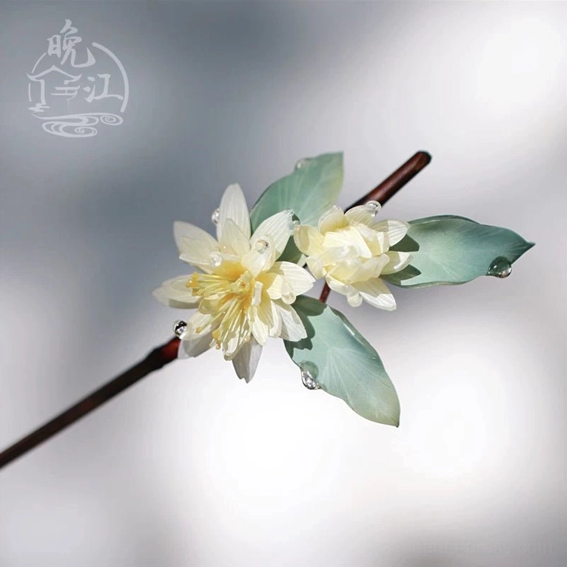 Right-side close-up of lotus themed Chinese hair stick with pale yellow layered petals muted green leaves dewdrop details and reddish brown wooden shaft