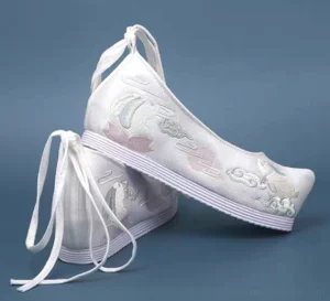 Side rear view of Lunar Bunny traditional Chinese Hanfu shoes with off-white embroidered uppers, pink moon cloud details, ankle ties, and platform rubber soles