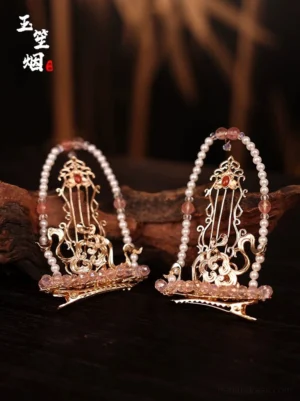 Close-up of harp-shaped Hanfu hair clips with gold-tone carved frames, red gemstone-style details, pearls and pink bead accents