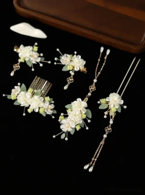 Complete magnolia Hanfu hair accessories set with white floral hair combs green leaves pearl details and gold-toned ornaments displayed on a black background