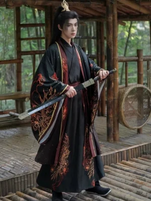 Front view of a male Wuxia Hanfu costume with layered cross-collar top, flowing wrap skirt, wide sleeves, red and gold detailing, and a traditional Chinese sword in a wooden pavilion