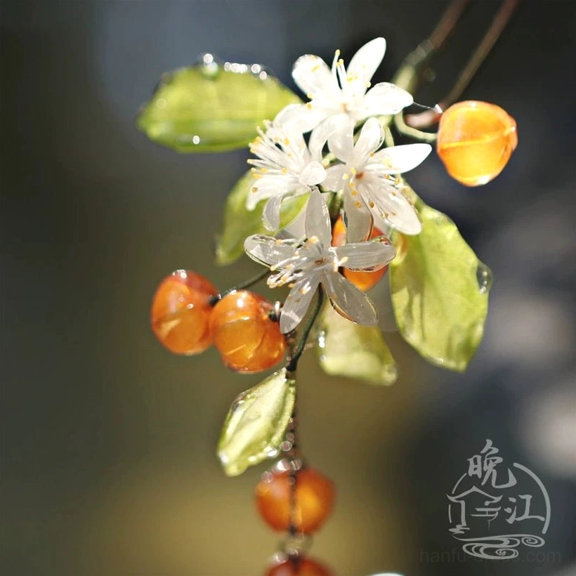 Close-up mandarin orange floral Chinese hair accessory featuring glossy resin leaves clustered white blossoms orange fruit beads and traditional-inspired decorative detailing