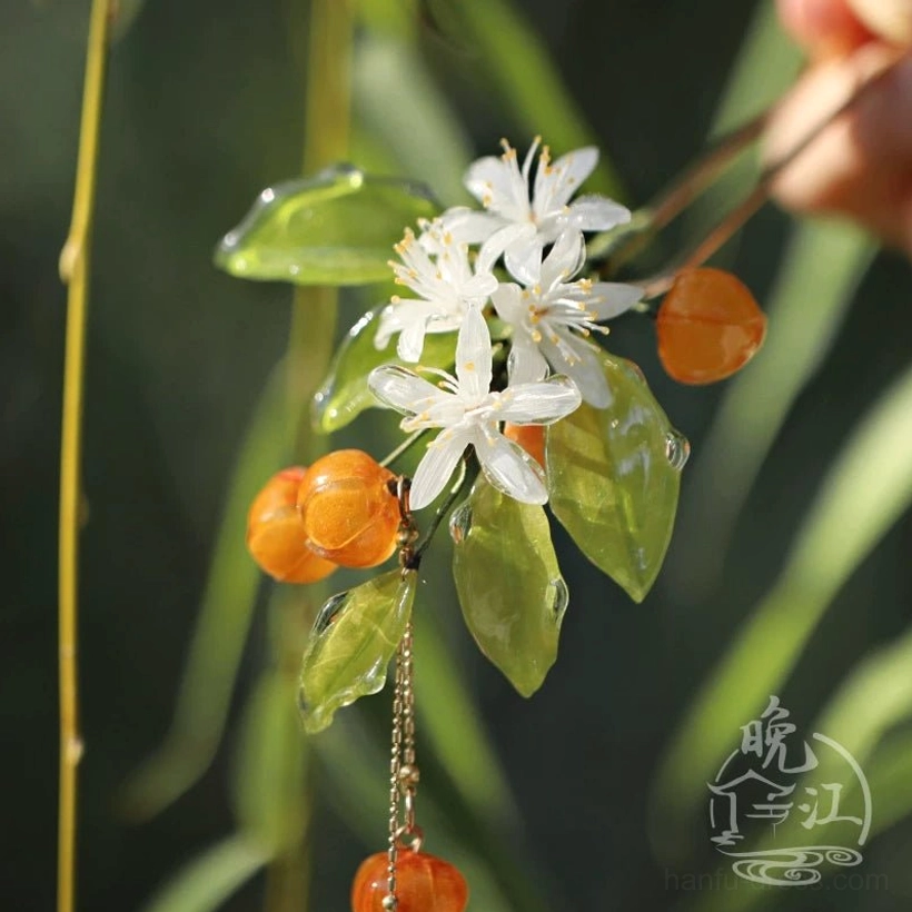 Traditional-inspired mandarin orange hairpin with green resin foliage white flower clusters orange fruit accents and double dangling gold-tone chains