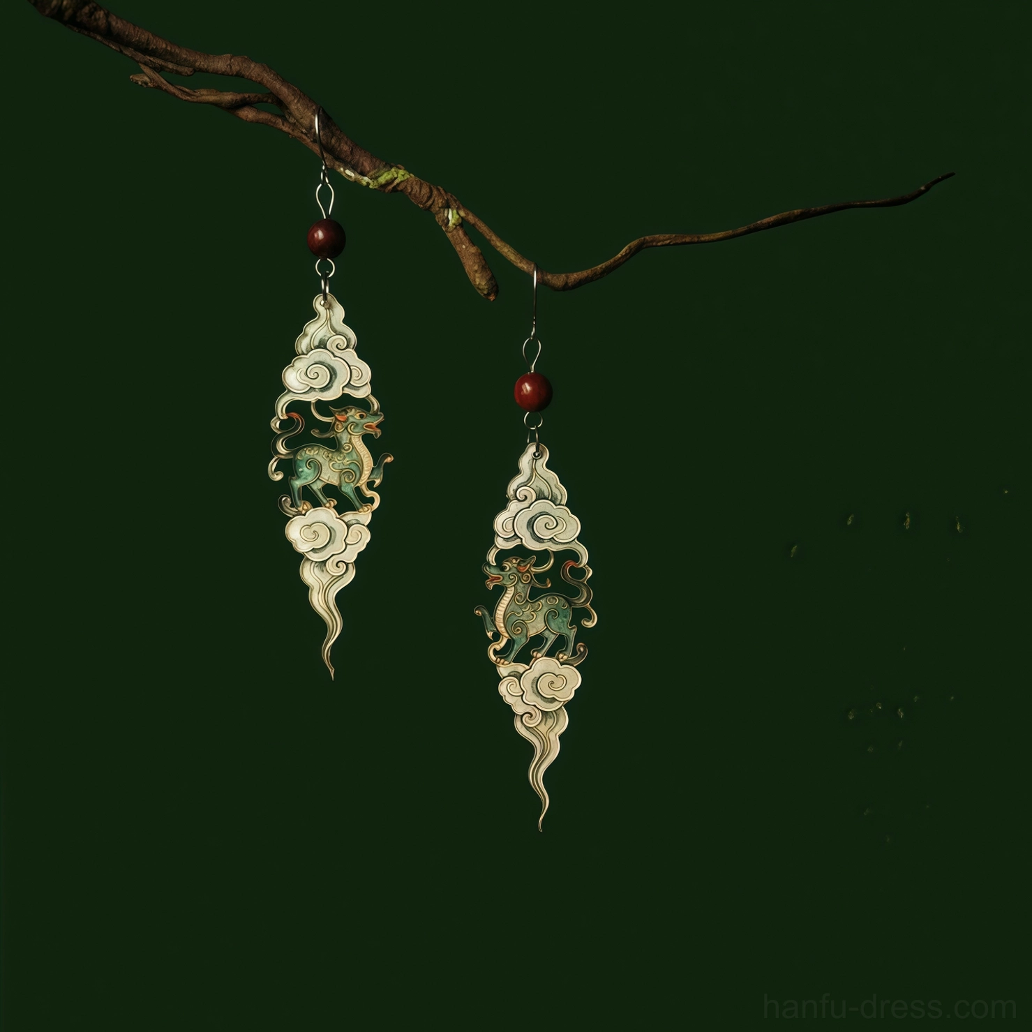 Matched pair of auspicious cloud Qilin Hanfu earrings shown from an angled view with green mythical creature details and red bead accents