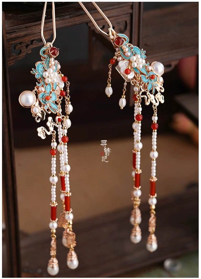 Matching pair of Chinese-style side hairpins with blue floral enamel, red agate accents, pearl beads, and water-drop tassel pendants shown from an overhead angle