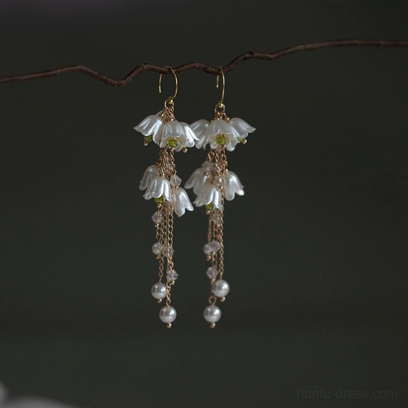 Matching pair of lily of the valley vintage earrings with gold hardware, milky white flower charms, chain tassels, beads, and imitation pearls