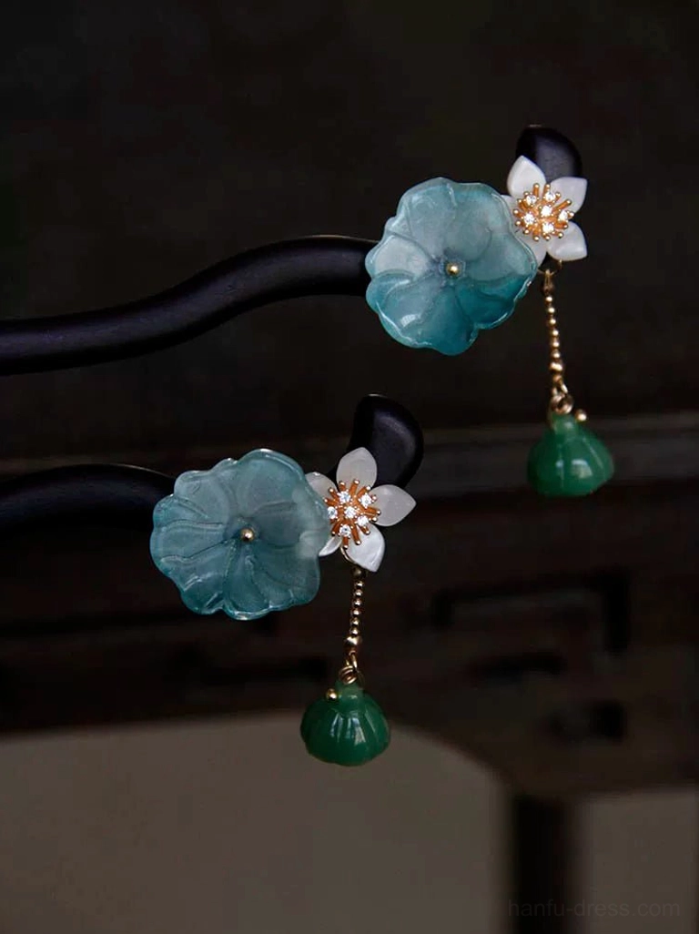 Matching lotus Chinese hair sticks shown from different angles with curved black wood shafts, translucent blue flowers, white blossoms, and hanging green lotus seed pods
