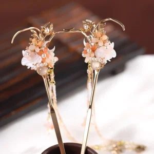 Matching pair of traditional Chinese tassel hair sticks with pink white flowers, pearl details, gold-toned ornaments, and layered chain pendants shown from the side