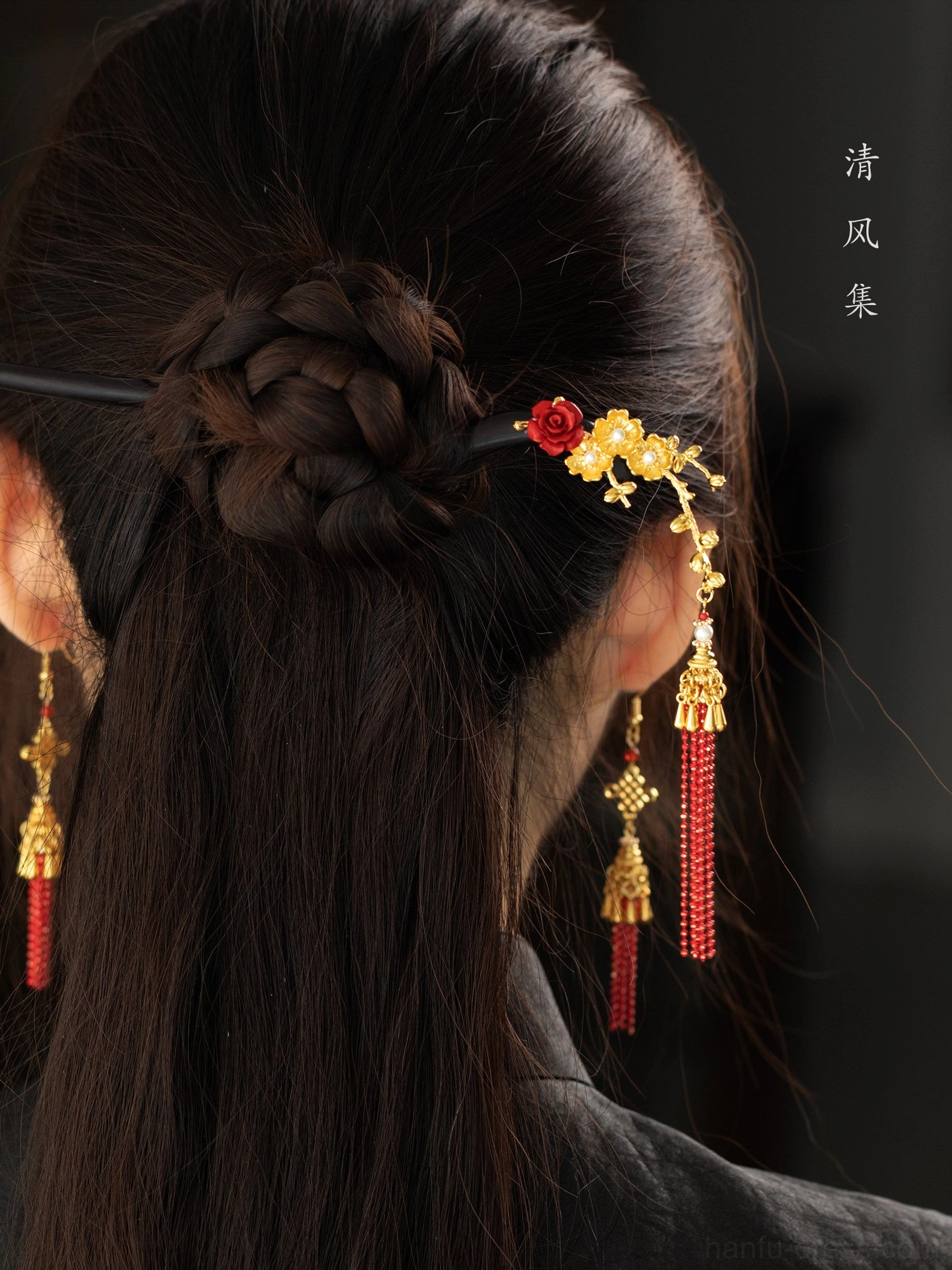 Back close-up of matching red Chinese knot tassel earrings and floral hairpin with low braided Hanfu hairstyle