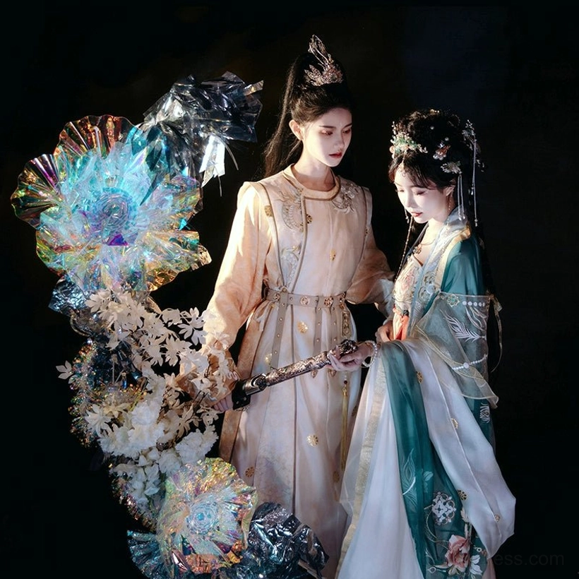 Two coordinated Chinese hanfu outfits displayed together, featuring a gold embroidered Tang style robe with waist belt and a green white floral hanfu costume