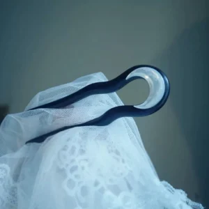Close-up of a matte black U-shaped Chinese hair stick with polished wood finish and luminous mother-of-pearl crescent moon decoration