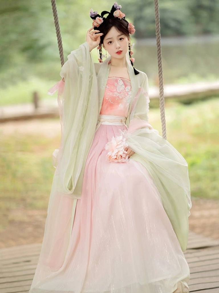 Pink gradient Tang Dynasty qiyao ruqun Hanfu set with light green wide sleeve coat and floral embroidered camisole on a wooden swing