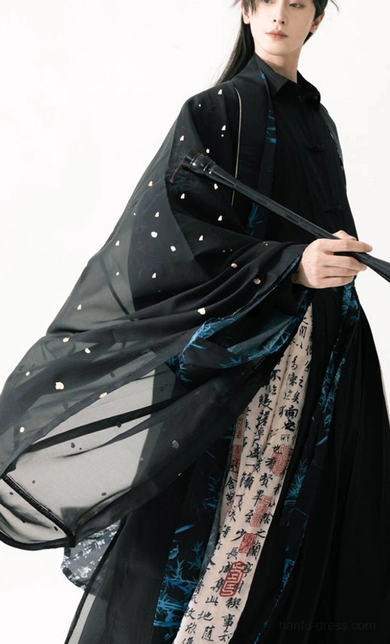 Three quarter view of a men’s black Taoist Hanfu robe with sheer wide sleeves, tiny gold sparkle details, blue accents, and calligraphy printed skirt panels