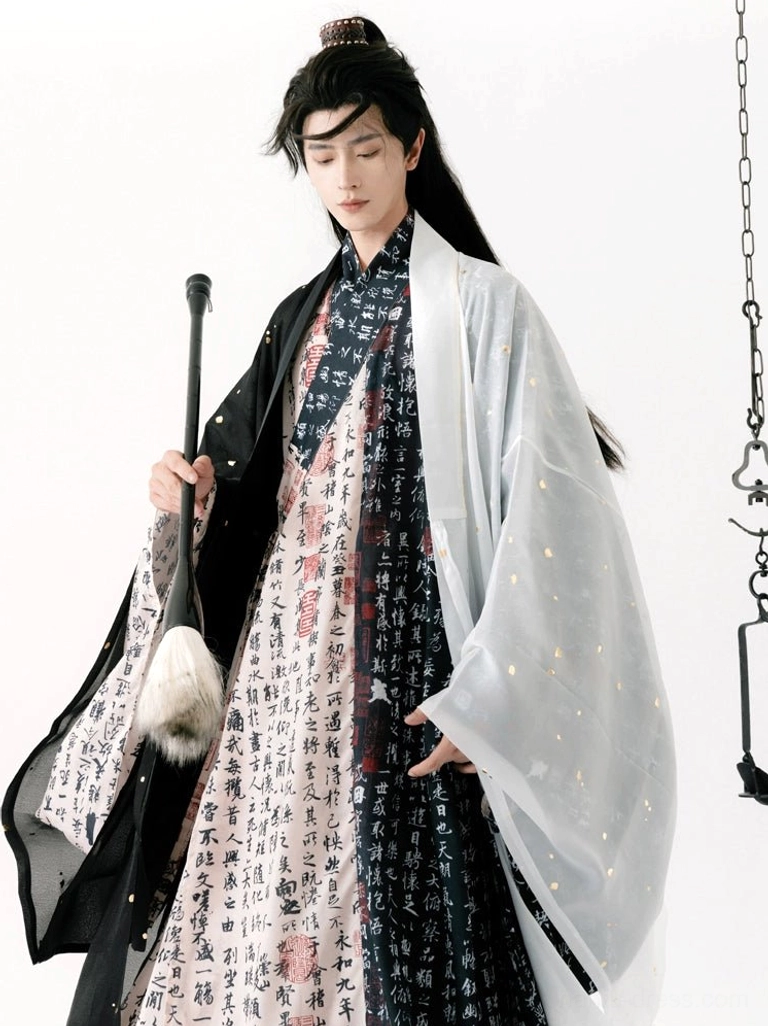 Men's black and white calligraphy hanfu robe and outer coat styled with a traditional writing brush in an artistic studio setting