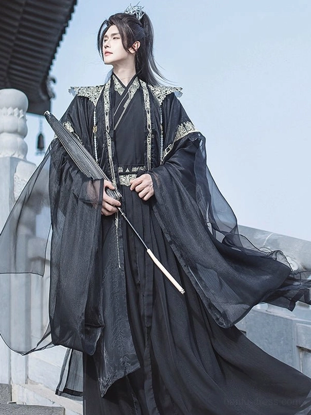 Black men's xianxia hanfu set with gold geometric trim and flowing sheer wide sleeves shown in a three-quarter standing pose