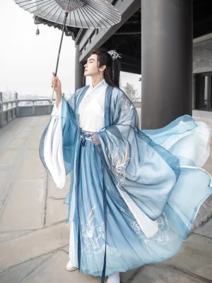 Men's blue gradient wuxia Hanfu with cross-collar top wide sleeves and delicate cloud embroidery styled with an oil-paper umbrella on a pavilion corridor