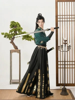 Men's emerald and black wuxia Hanfu set with cross-collar top, flowing wrap skirt, gold vertical patterns, leather wrist guards, and sword accessories in a traditional Chinese interior