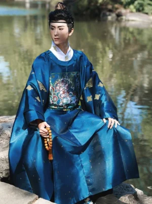 Men wearing royal blue Ming Dynasty yuanlingpao Hanfu robe with gold star-like shimmer and mythical beast buzi embroidery by a waterside setting