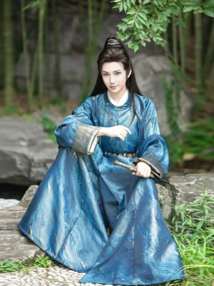 Men's deep blue Tang Dynasty round-collar Hanfu robe with water-wave jacquard texture, gold-trimmed cuffs, black waist sash, and traditional sword in a classical Chinese garden