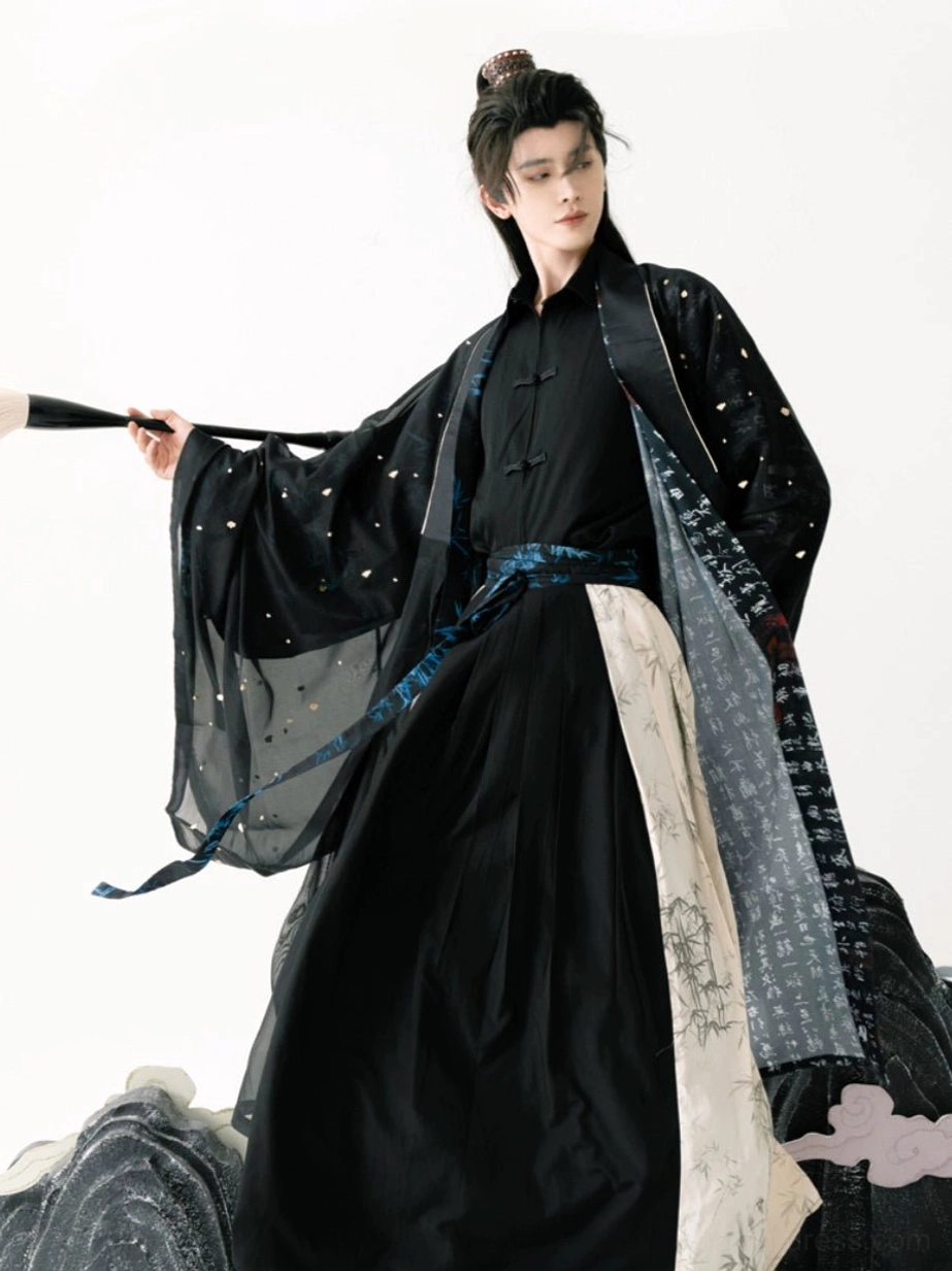 Three quarter view of a men’s Taoist Hanfu robe with sheer wide sleeves, subtle sparkling dots, blue waist sash, bamboo details, and calligraphy inspired styling