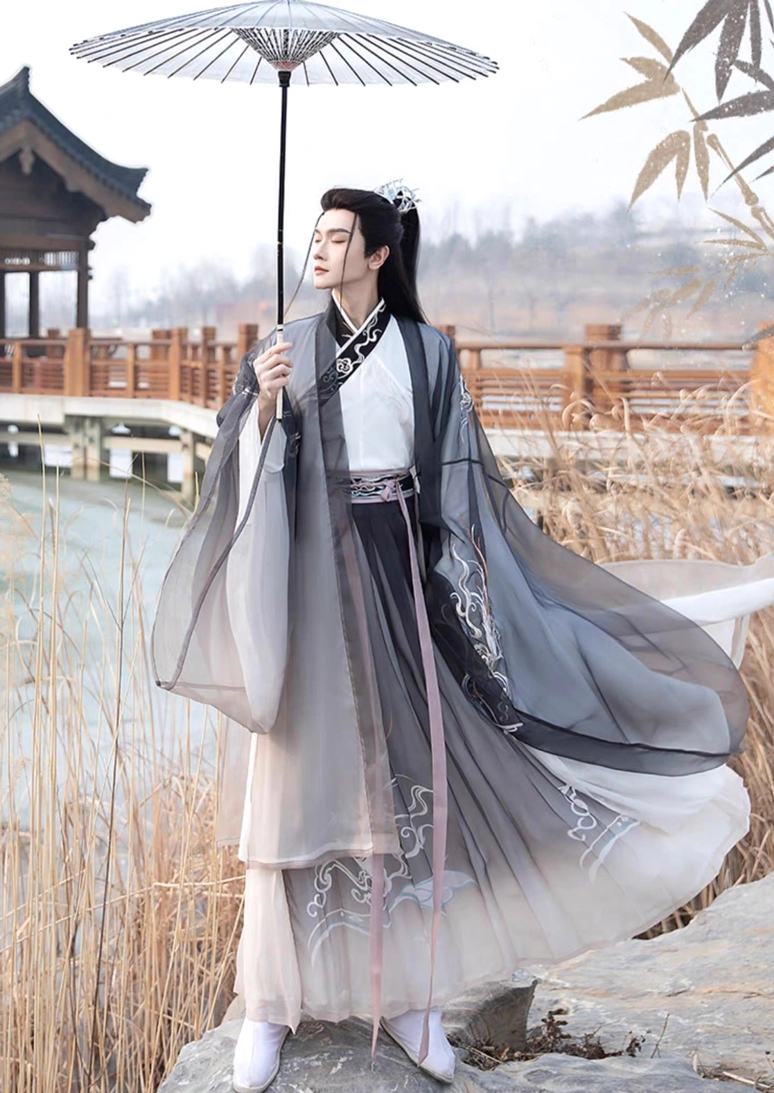 Thunder black and pink gradient men's Hanfu set with traditional cross-collar design and wide sleeves styled with an oil-paper umbrella among lakeside reeds