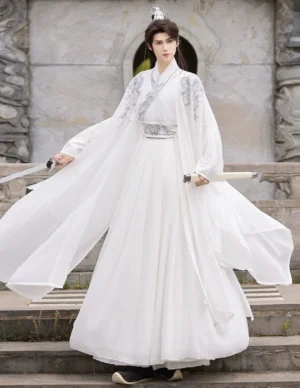 Full-body male model wearing an all-white men's Wei-Jin Hanfu cross-collar knight outfit with silver shoulder and waist patterns, flowing sheer outer coat, pleated wrap skirt, traditional Chinese hair crown, and sword props on outdoor stone stairs