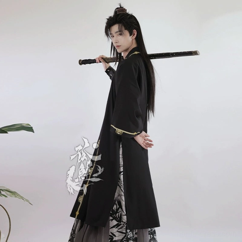 Side back view of men's wuxia Hanfu with flowing black outer robe, gold cuff trim, bamboo patterned skirt, and long sword
