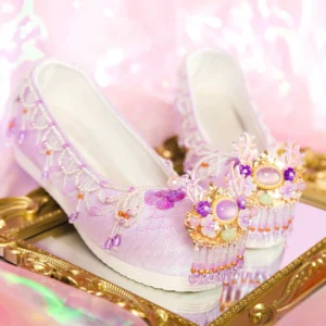 Light purple mermaid magic Hanfu shoes with fish-scale jacquard fabric, gold gemstone toe ornaments and crystal tassels displayed on ornate golden mirror
