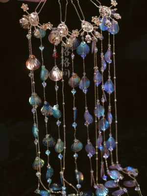 Flat lay of long mermaid shell tassel hair ornaments featuring golden chains iridescent shell pendants crystal-like beads and Hanfu styling details